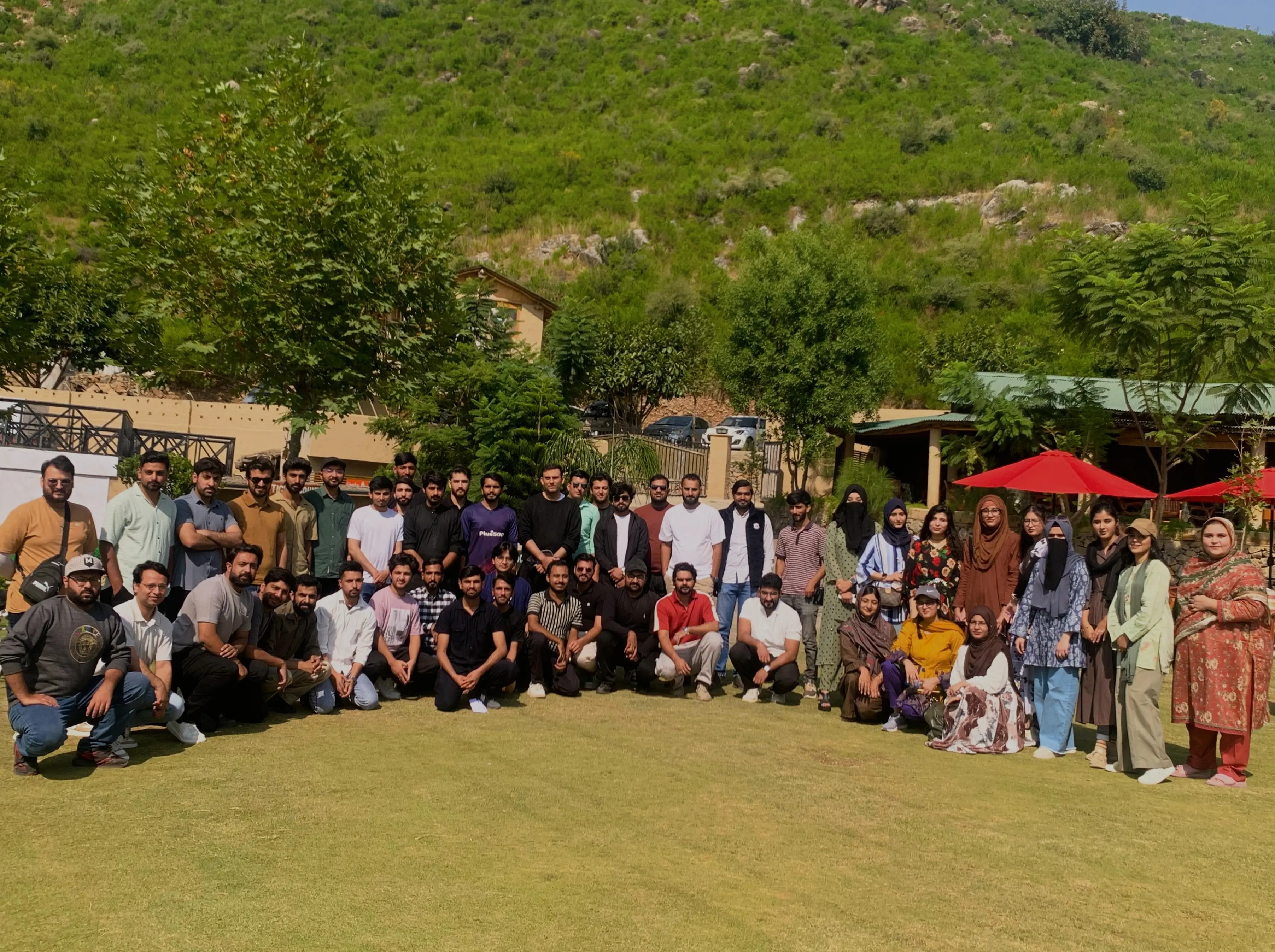 The whole team gathered on a lawn below green hills on Funavry's day out