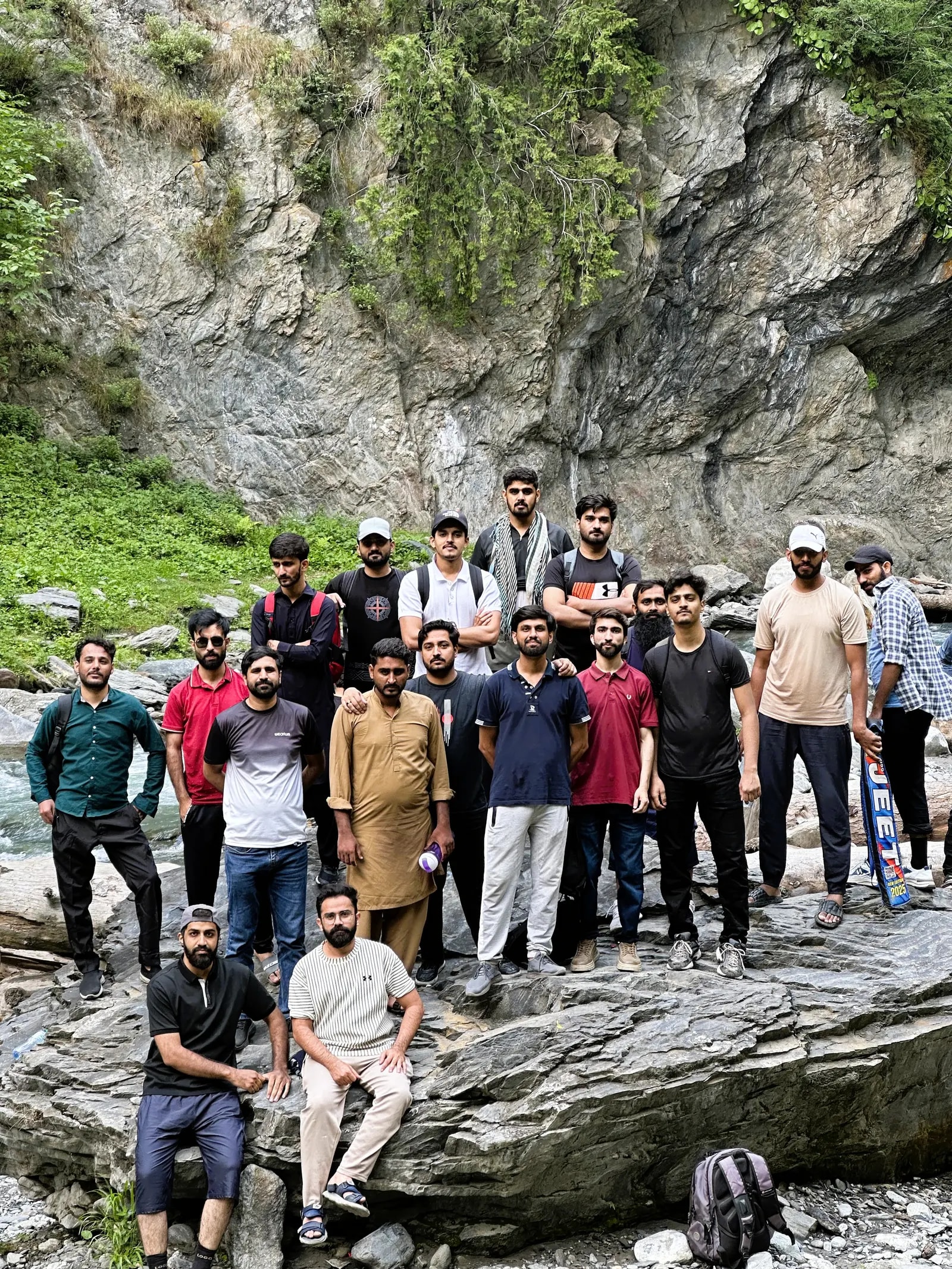 A group of colleagues on the rocks of a mountain stream on a trip