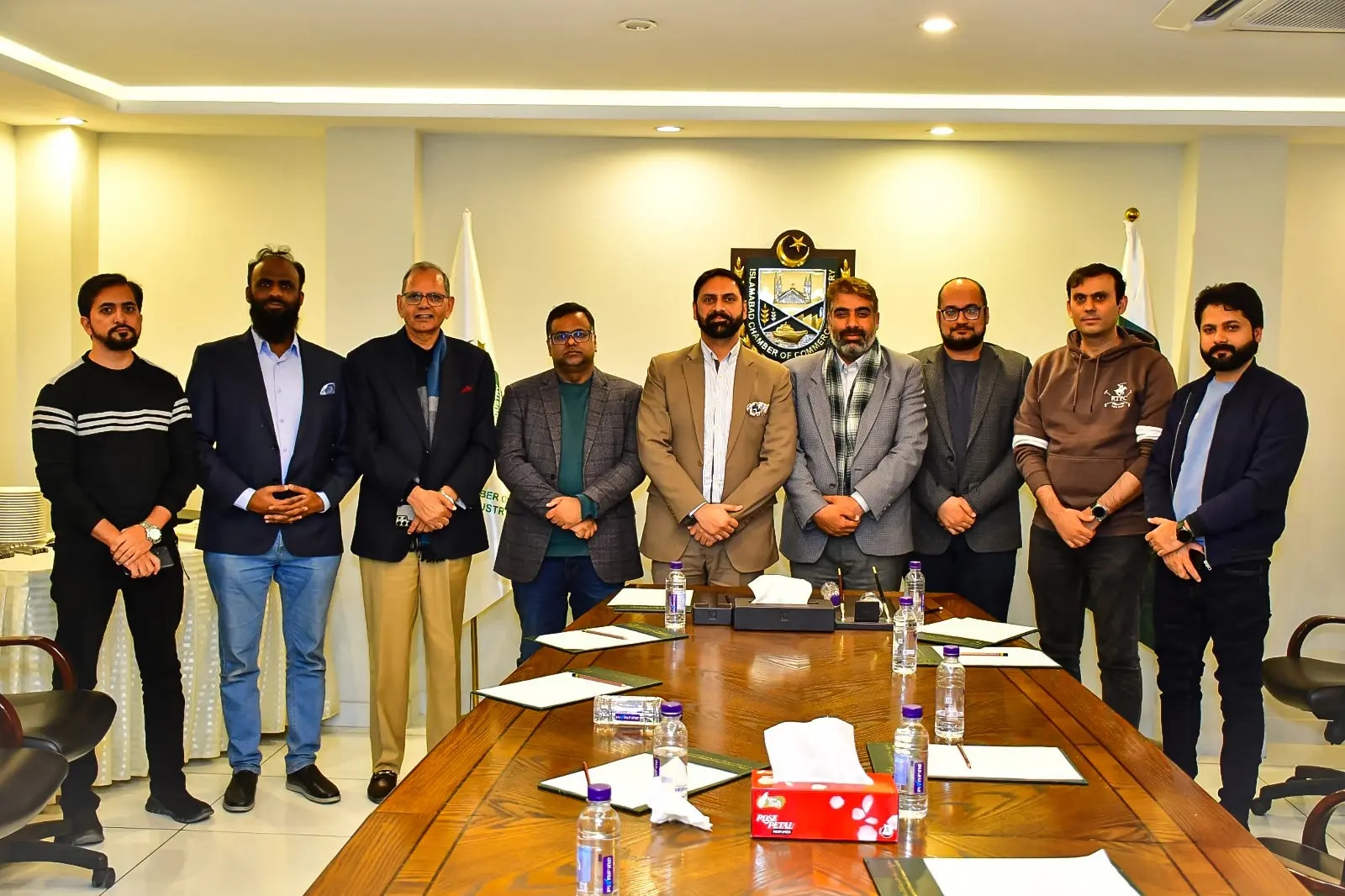 Team members standing together behind the boardroom table at the Islamabad Chamber of Commerce and Industry