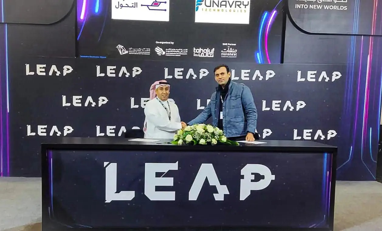 Two people shaking hands at a signing table under LEAP and Funavry branding at the LEAP technology event
